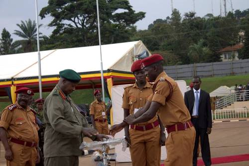 President Museveni handing over a prize to one of the best performers in training